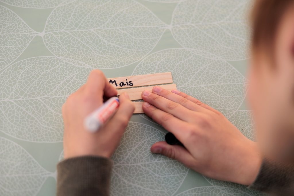 Kind bemalt Pflanzschilder